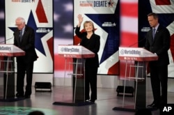FILE - Hillary Clinton waves as Bernie Sanders, left, and Martin O'Malley prepare before a Democratic presidential primary debate, Nov. 14, 2015, in Des Moines, Iowa.
