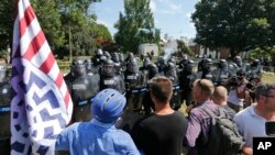 白人民族主义者在罗伯特·李将军雕像前对维吉尼亚州警对峙，之前警察也发射了催泪弹驱散人群。（2017年8月12日）