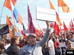 在2012年5月6日普京就职总统前的莫斯科大规模反政府示威上，一名抗议者手举标语，“普京是非法总统”(美国之音白桦拍摄)