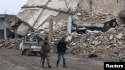 30일 시리아 알레포 외곽 알-라이 마을에서 반군 병사들이 무너진 건물터를 지나고 있다.