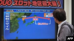 یک شهروند کره جنوبی مقابل تلویزیونی که مسیر موشک جدیدا آزمایش شده کره شمالی را نشان می دهد. 