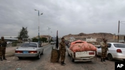 2013年8月4日也门军人在通往美国驻也门首都萨那大使馆的一个检查站检查车辆。