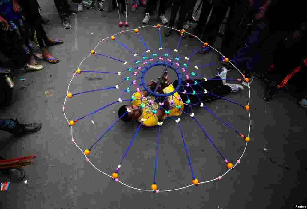 Seorang umat Hindu memperagakan Gatka, sebuah bentuk seni bela diri tradisional, selama latihan untuk upacara tahunan Rath Yatra, atau prosesi kereta perang, yang memperingati perjalanan dewa Hindu Jagannath, saudaranya Balabhadra, dan saudara perempuannya Subhadra, dalam kereta perang yang dibuat khusus, di Ahmedabad, India.