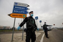 FILE - Carabinieri officers patrol an access road to Bollate, in the outskirts of Milan, Italy, Feb. 18, 2021. Italy’s Lombardy region asked the national government Feb. 25 to send more vaccines north to help stem a surge of new COVID cases.