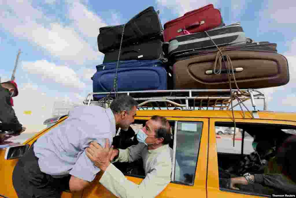 코로나바이러스 확산 방지를 위해 닫혀있다 재개된 팔레스타인 가자지구와 경계지역인 이집트 라파 국경을 넘기전 검문소에서 팔레스타인이 가족과 인사를 나누고 있다. 