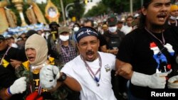 在曼谷，抗议者呼喊口号准备冲击警察封锁线。(2013年11月25日)