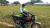 FILE - Yunusa Bawa, a community health worker, rides on a motorbike with a box of AstraZeneca coronavirus vaccines, in Sabon Kuje on the outskirts of Abuja, Nigeria, Dec 6, 2021.
