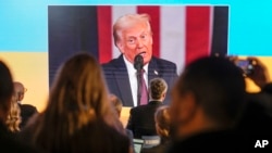 Para peserta menyaksikan pelantikan Presiden AS Donald Trump di layar, di sela acara Forum Ekonomi Dunia di kota Davos, Swiss, Senin, 20 Januari 2025.