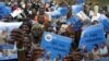 Parents, guardians, friends and relatives sing traditional songs and carry HIV/AIDS prevention posters in Njoloma village, Malawi