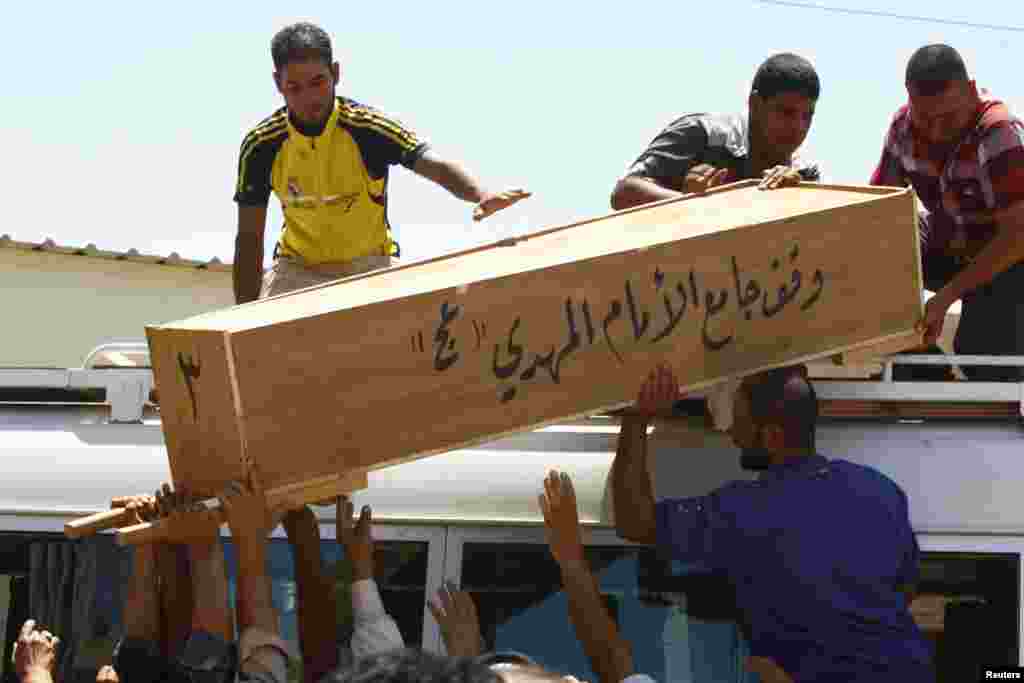 Relatives carry the coffin of victim killed in Tuesday&#39;s bomb attacks, during a funeral in Najaf, 160 km (100 miles) south of Baghdad, July 3, 2013.