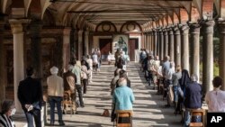 Faithful attend a Mass in the courtyard of La Fontana church, in Milan, Italy, May 18, 2020. 