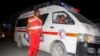 FILE - Medical workers wait by ambulances after a bomb attack at an ice cream shop in Mogadishu, Somalia, Nov. 27, 2020. 