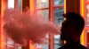 FILE - A patron exhales vapor from an e-cigarette at the Henley Vaporium in New York