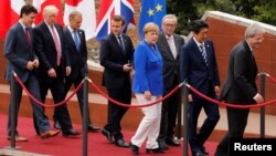 이탈리아 시실리아 섬에서 열린 주요 7개국 정상회의에 참석한 정상들이 단체사진을 찍은 후 자리를 떠나고 있다. 왼쪽부터 쥐스탱 트뤼도 캐나다 총리, 도널드 트럼프 미국 대통령, 도날트 투스크 EU 정상회의 상임의장, 에마뉘엘 마크롱 프랑스 대통령, 앙겔라 메르켈 독일 총리, 장클로드 융커 EU 집행위원장, 아베 신조 일본 총리, 파올로 젠틸로니 이탈리아 총리.