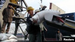 북한 남포항에서 인부들이 유엔 산하 세계식량계획을 통해 지원된 식량을 트럭에 싣고 있다. (자료사진)