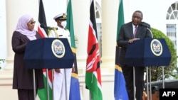Rais wa Kenya Uhuru Kenyatta, kulia akimsikiliza rais wa Tanzania Samia Suluhu Hassan akizungumza wakati wa mkutano wao na waandishi huko Ikulu ya Nairobi, May 4, 2021. 