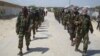 FILE - Members of Somalia's al-Shabab militant group patrol on foot on the outskirts of Mogadishu, Somalia, March 5, 2012. 