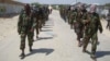 FILE - Members of Somalia's al-Shabab militant group patrol on foot on the outskirts of Mogadishu, March 5, 2012. Somalia now says al-Shabab militants are plotting to supply uranium to Iran.