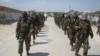 FILE - Members of Somalia's al-Shabab militant group patrol on foot on the outskirts of Mogadishu, Somalia, March 5, 2012. 