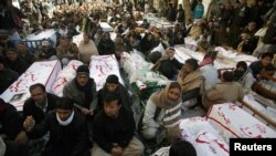 Shi'ite Muslims display the unburied coffins of victims of Thursday's twin bomb attack during a sit-in in Quetta, January 12, 2013.