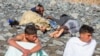 Spain: Sunbathers Help Migrants Arriving to Beach by Boat