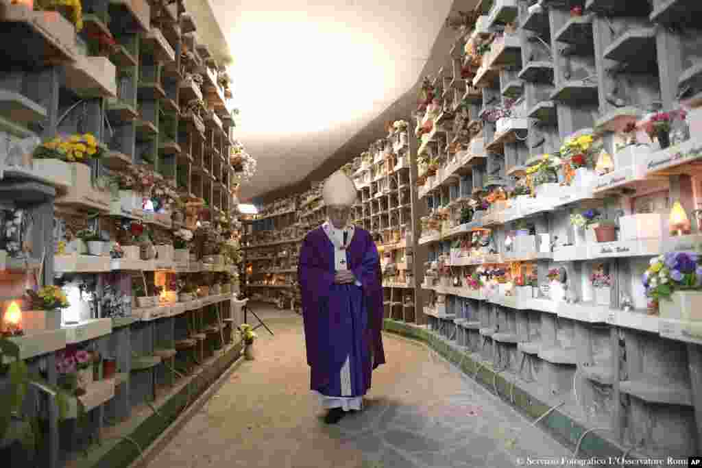 Pope Francis walks past graves at the Prima Porta Cemetery in Rome, Italy, to celebrate a Mass on the occasion of All Souls&#39; Day.