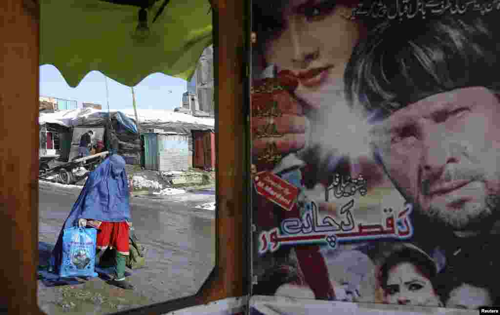 An Afghan woman is reflected in a mirror at a small music shop in Kabul.