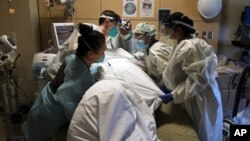 រូបឯកសារ៖ បុគ្គលិកពេទ្យ​នៅ​មជ្ឈមណ្ឌល​វេជ្ជសាស្ត្រ Providence Holy Cross ក្នុង​ទីក្រុង Los Angeles រដ្ឋកាលីហ្វ័រញ៉ា ពិនិត្យមើលអ្នកជំងឺ​កូវីដ១៩ កាលពី​ថ្ងៃទី១៩ ខែវិច្ឆិកា ឆ្នាំ២០២០។