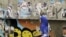 An Egyptian woman passes by a wall with defaced posters of presidential candidates in Cairo, Egypt, Monday, May, 21, 2012.