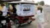 An election campaign poster of Prime Minister Hun Sen's ruling Cambodian People's Party hangs on the back of a motorized rickshaw parked at a blocked street in front of the Royal Palace in Phnom Penh.