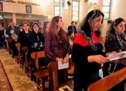 FILE - Iraqi Catholics pray during Mass at Mar Youssif Chaldean church, in Baghdad, Iraq, Dec. 25, 2018.