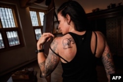 Lilian Ramcharan, a security manager at Rembrandt House Museum looks on after receiving a tattoo of 'Rembrandt’s elephant' by Dutch tattoo artist Henk Schiffmacher at The Rembrandt House Museum in Amsterdam on June 19, 2023.(Photo by SIMON WOHLFAHRT / AFP)