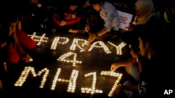 Warga menyusun lilin untuk menghormati para korban jatuhnya pesawat Malaysia Airlines penerbangan MH17, di sebuah pusat perbelanjaan di Petaling Jaya, dekat Kuala Lumpur, Malaysia (18/7). (AP/Joshua Paul)