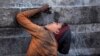 An Indian ragpicker boy drinks water from a tap at an automobile yard on the outskirts of Jammu, India.