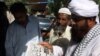 People read newspapers at a news stand carry headlines "Osama bin Laden killed." in Hyderabad, Pakistan on Monday, May 2, 2011.