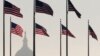 The U.S. Capitol Dome is seen in the distance as American flags fly on the National Mall around the base of the Washington Monument, Oct. 15, 2013.