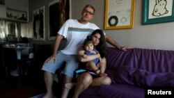 Tatiana Barcellos, 37, seorang pegawai negeri sipil untuk Kantor Kejaksaan Federal, putrinya yang berusia delapan bulan, Alice, dan suaminya Marcelo Valenca, 39, seorang guru di sebuah sekolah angkatan laut (Foto: Reuters)