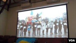 2014年在莫斯科的一场研讨会上，乌克兰活动人士展示国旗和乌克兰反政府示威活动视频。