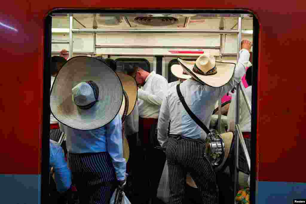 Military personnel wearing traditional costumes travel in the metro to Zocalo Square, to participate in a parade to mark the 114th anniversary of the Mexican Revolution, in Mexico City, Mexico.