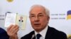 Ukraine's former prime minister, Mykola Azarov, displays his Ukrainian internal passport at a press conference in Moscow, August 3, 2015