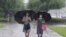 Women walk with umbrellas during torrential rains, Aug. 5, 2020, in Pyongyang. North Korea says torrential rains have lashed the country, prompting outside worries about possible severe damages in the impoverished country. 