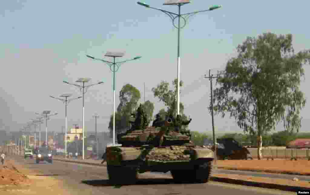 A tank patrols one of the main roads in the South Sudanese capital Juba, Dec. 16, 2013. The South Sudanese president declared a curfew in the capital Juba on Monday after clashes overnight between rival factions of soldiers.