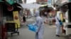 Workers wearing a protective suit spray disinfectant as a precaution against the COVID-19 at a market in Seoul, South Korea, Wednesday, Feb. 26, 2020.