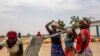 FILE - Women fetch water at the Minawao refugee camp near Gadala, Cameroon, March 3, 2020. The camp hosts over 60,000 Nigerian refugees. 