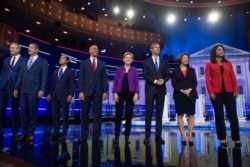 FILE - Democratic presidential hopefuls, from left, Bill de Blasio, Tim Ryan, Julian Castro, Cory Booker, Elizabeth Warren, Beto O'Rourke, Amy Klobuchar and Tulsi Gabbard arrive to the first Democratic primary debate in Miami, June 26, 2019.