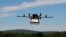 FILE - A prototype drone is seen carrying a parcel for delivery.