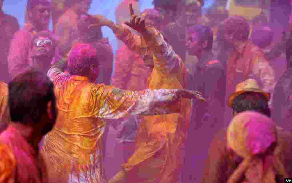 Warga India menghiasi tubuh mereka dengan bedak berwarna dan menari-nari selama perayaan keagamaan Hindu Holi di kota Hyderabad, India.