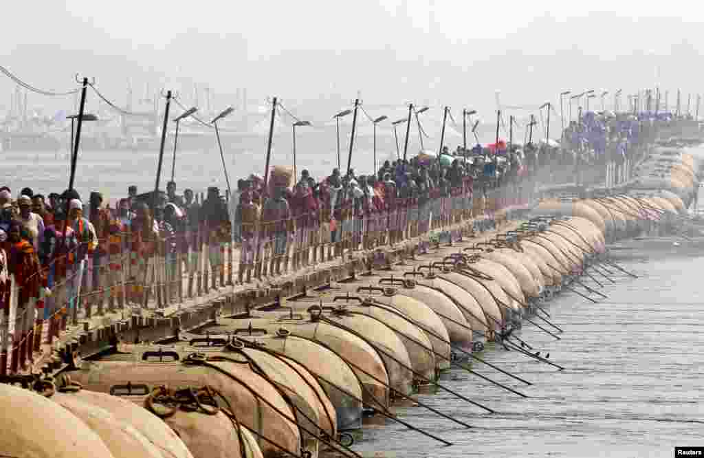 សាសនិក​ជន​បាន​ឆ្លង​កាត់​ស្ពាន​បណ្តែត​ទឹក​មួយ​បន្ទាប់​ពី​បាន​មុជទឹក​នៅ​ទន្លេ​ Sangam​ អំឡុង​ពិធី​បុណ្យ​ Magh Mela ក្នុង​ទីក្រុង​ Allahabad ប្រទេស​ឥណ្ឌា។