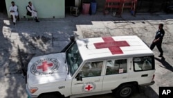 Un policier Afghanistan marche près d’un véhicule de la Croix rouge à Jalalabad, à l’est de Kaboul, Afghanistan, 30 mai 203.