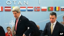 Menhan AS John Kerry (kiri) dan Sekjen NATO Anders Fogh Rasmussen sesaat sebelum dimulainya pertemuan Menlu NATO dari 28 negara di Brussels (23/4).
